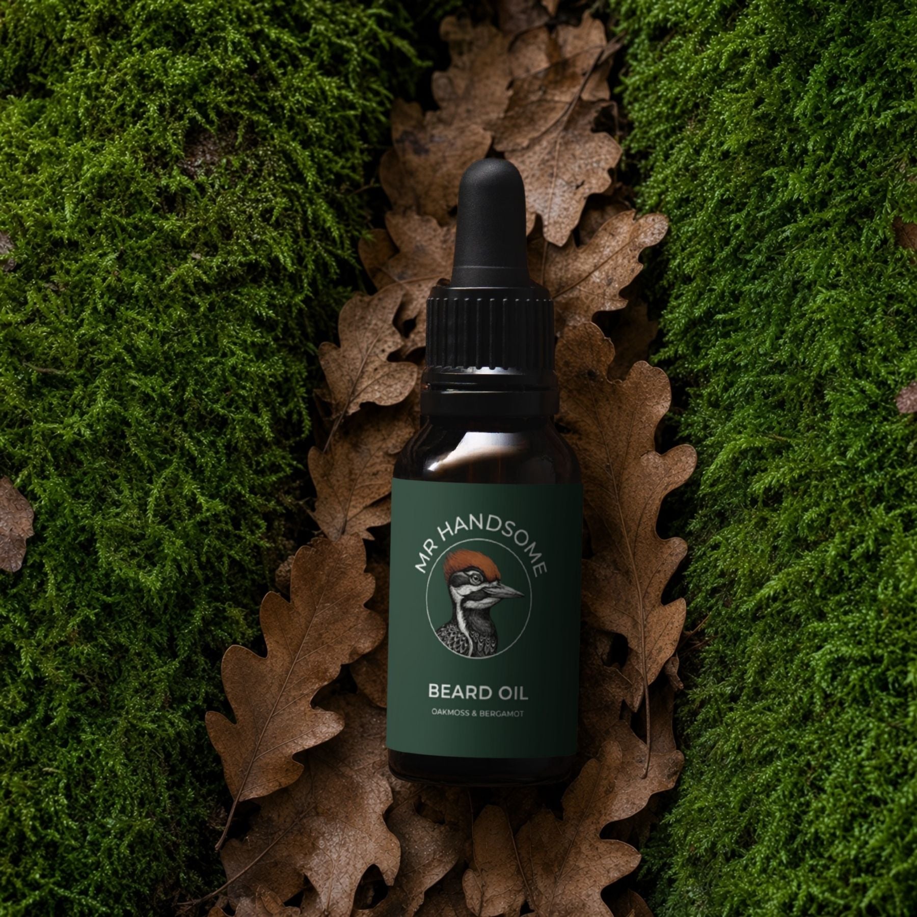 An image of the Organic Beard Oil by MR HANDSOME laying on oak leafs and moss