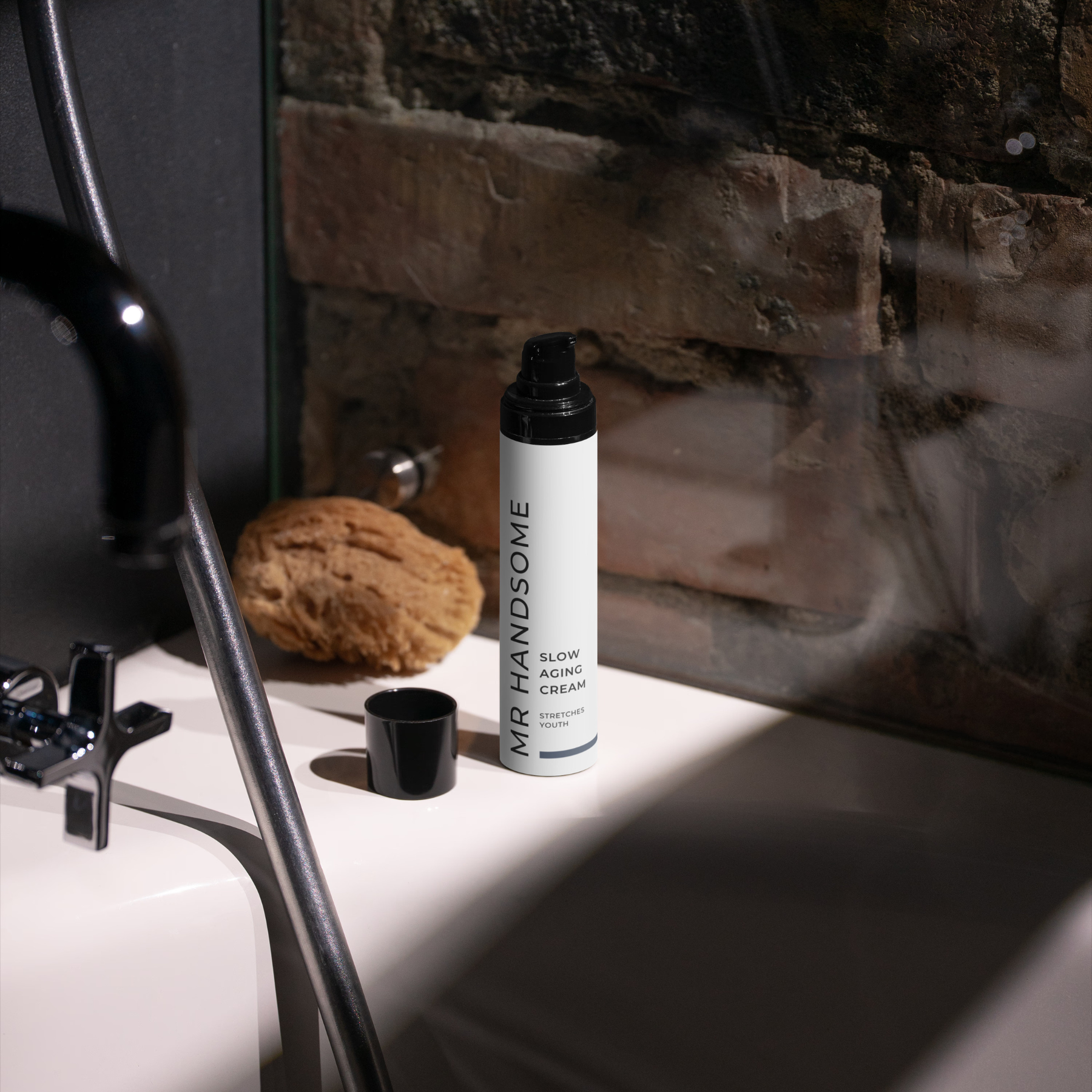MR HANDSOME Slow Aging Cream-Pumpe auf Waschtisch vor Backsteinwand.