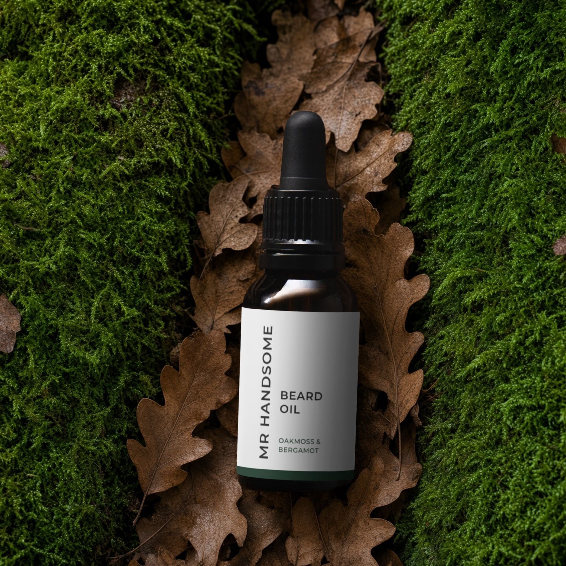 An image of the Organic Beard Oil by MR HANDSOME laying on oak leafs and moss