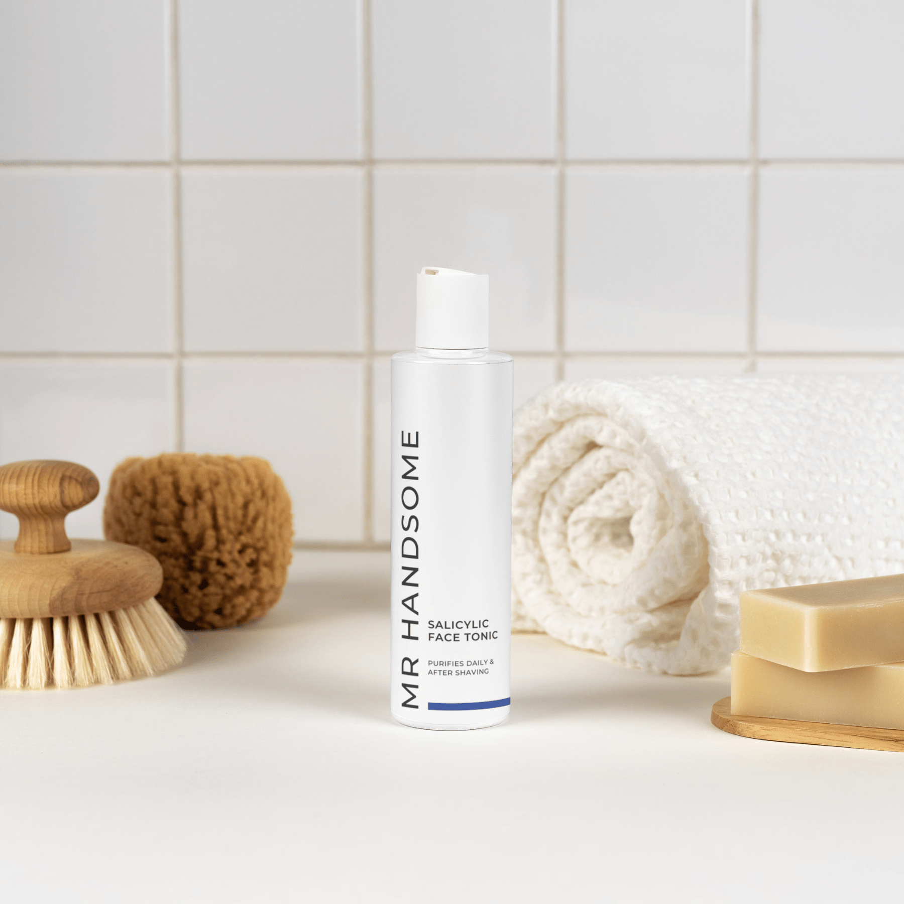Salicylic Face Tonic Flasche mit Pumpenspender auf Badezimmeroberfläche, umgeben von Seife, Bürsten und Handtuch.