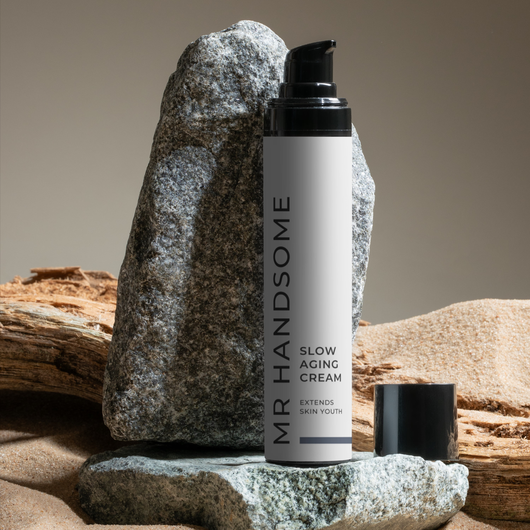 Slow Aging Cream – verlängert Hautjugend; Pumpflasche auf Stein am Strand